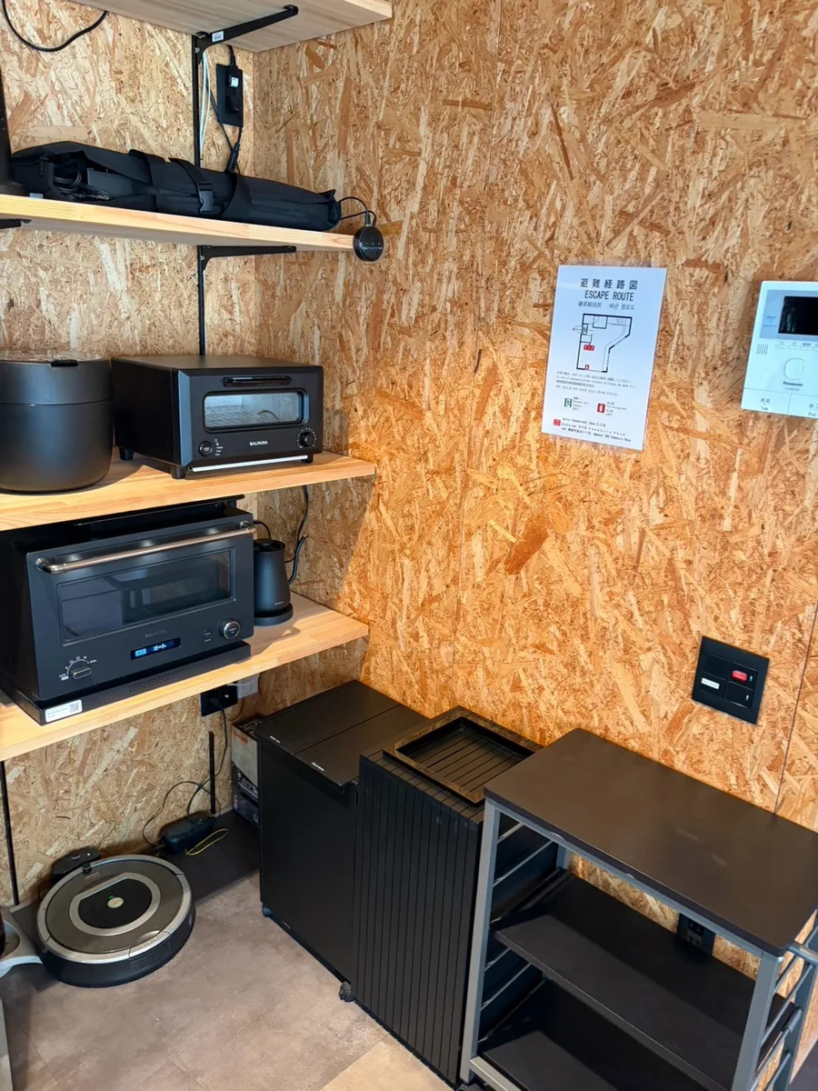 木製の棚に炊飯器やオーブンなどの家電を配置した室内