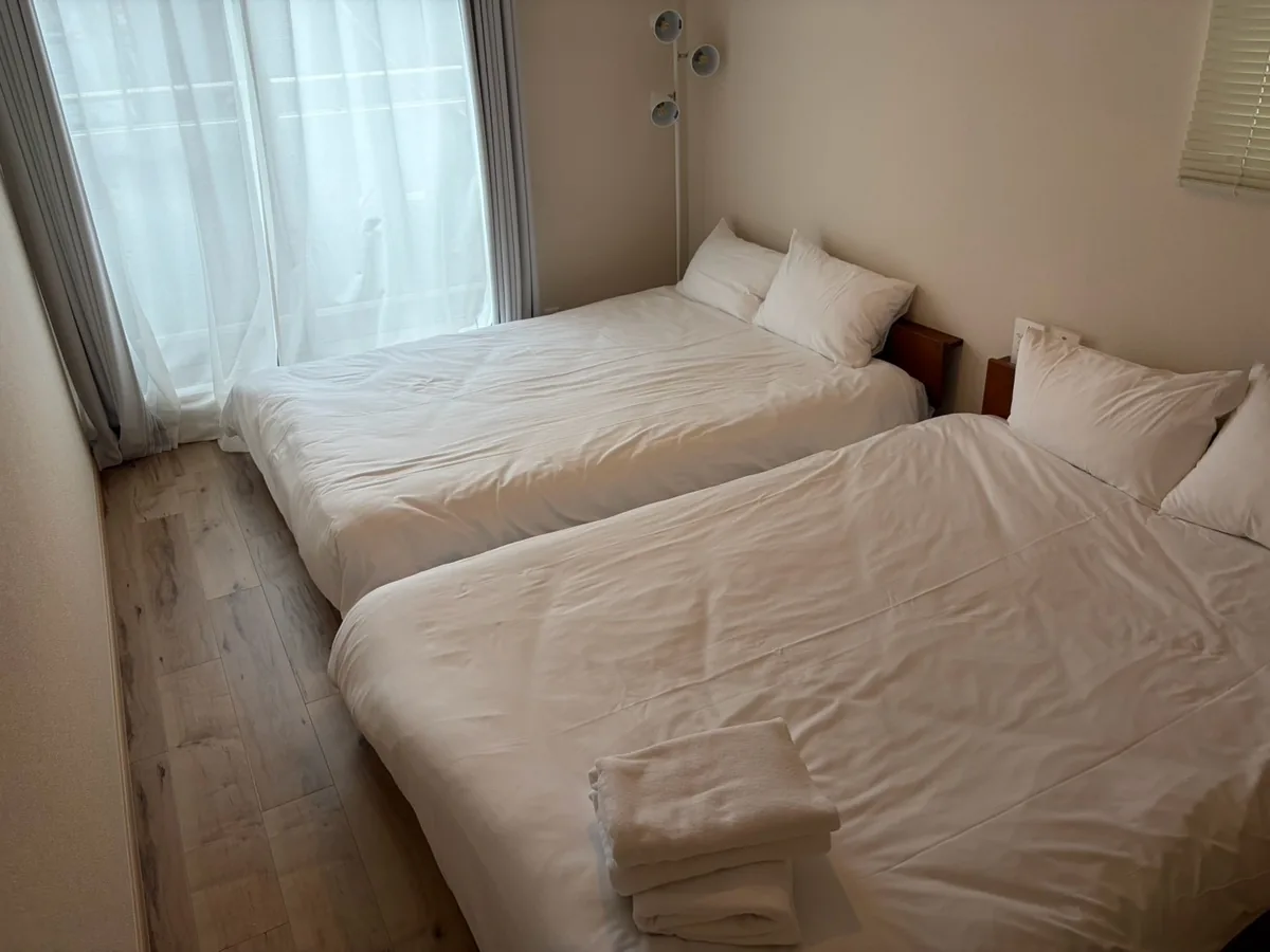 白い寝具とタオルを整えたベッド