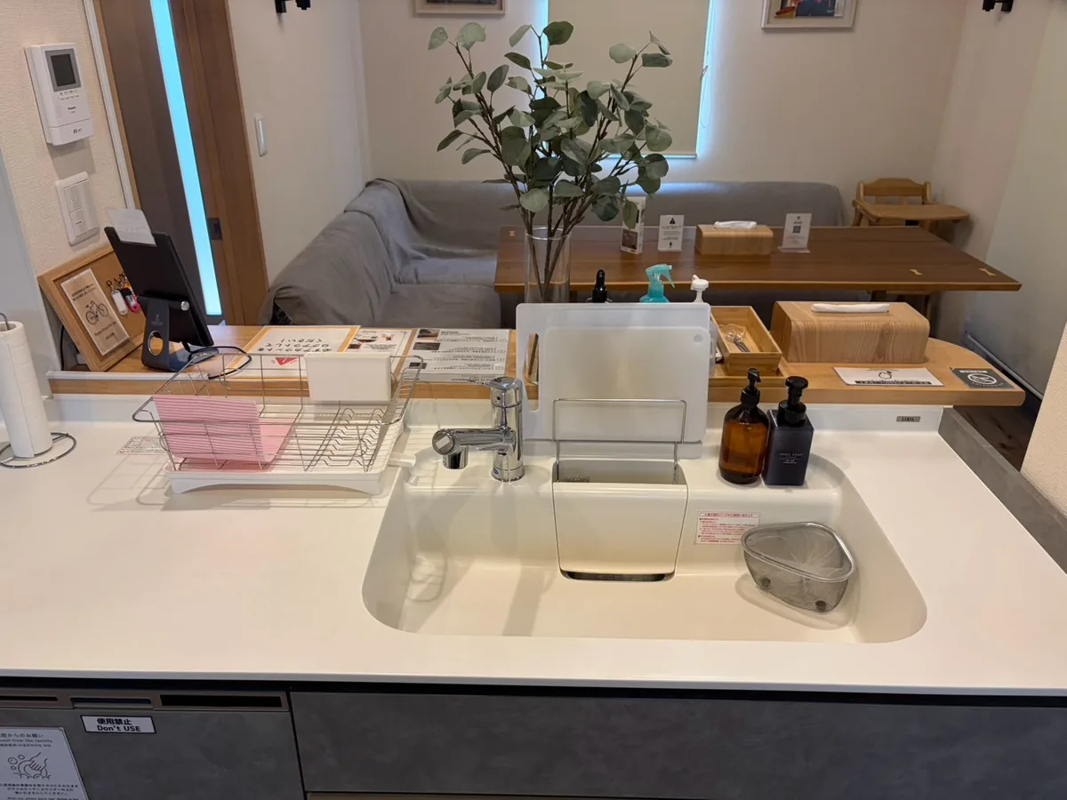 白いキッチンシンクと、水切りかごやまな板を揃えた作業台