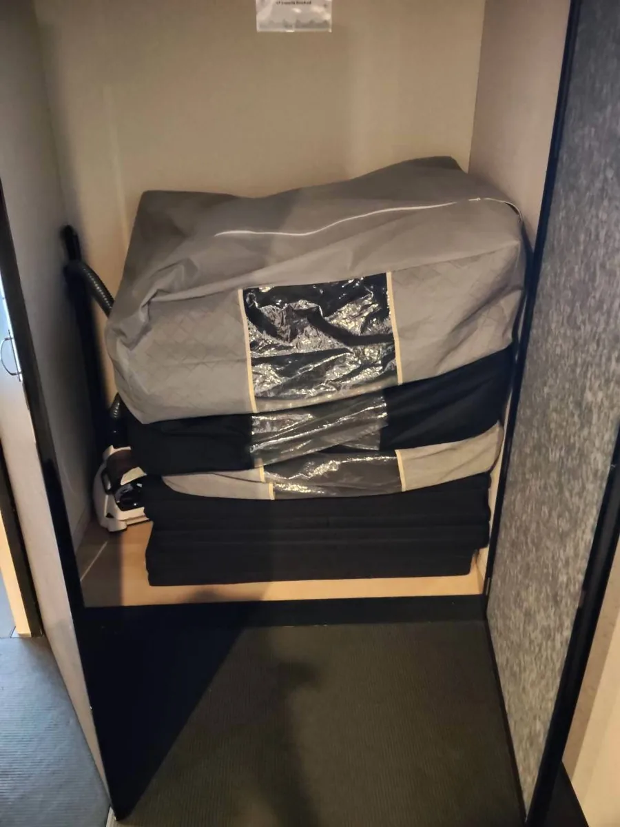 収納袋に入れた寝具と折り畳んだマット
